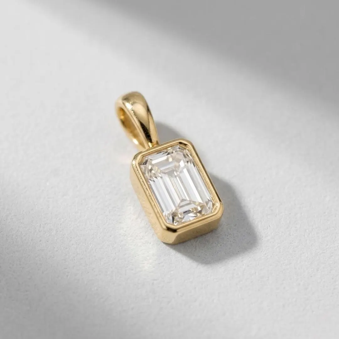 AuvelleCo emerald cut diamond bezel pendant in yellow gold