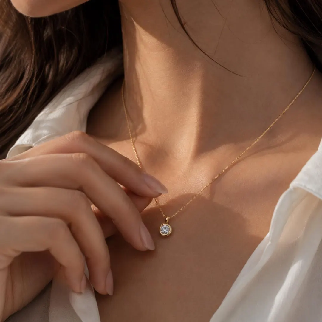 Round bezel diamond pendant styling; chain not included