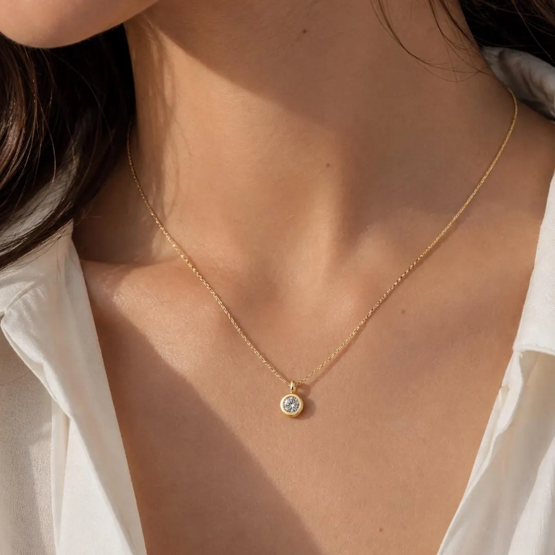 Round bezel diamond pendant styling; chain not included