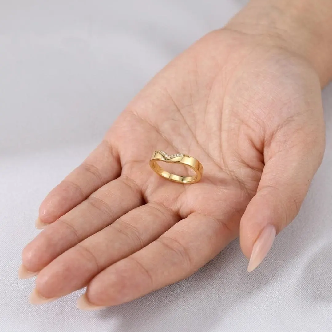 V Shaped Diamond Chevron Wedding Band — Yellow gold held in palm